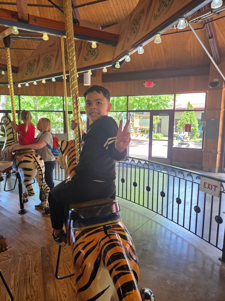 Student riding the tiger carousel.
