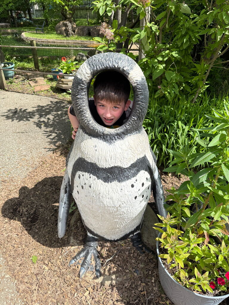 Student inside a large penguin photo prop.