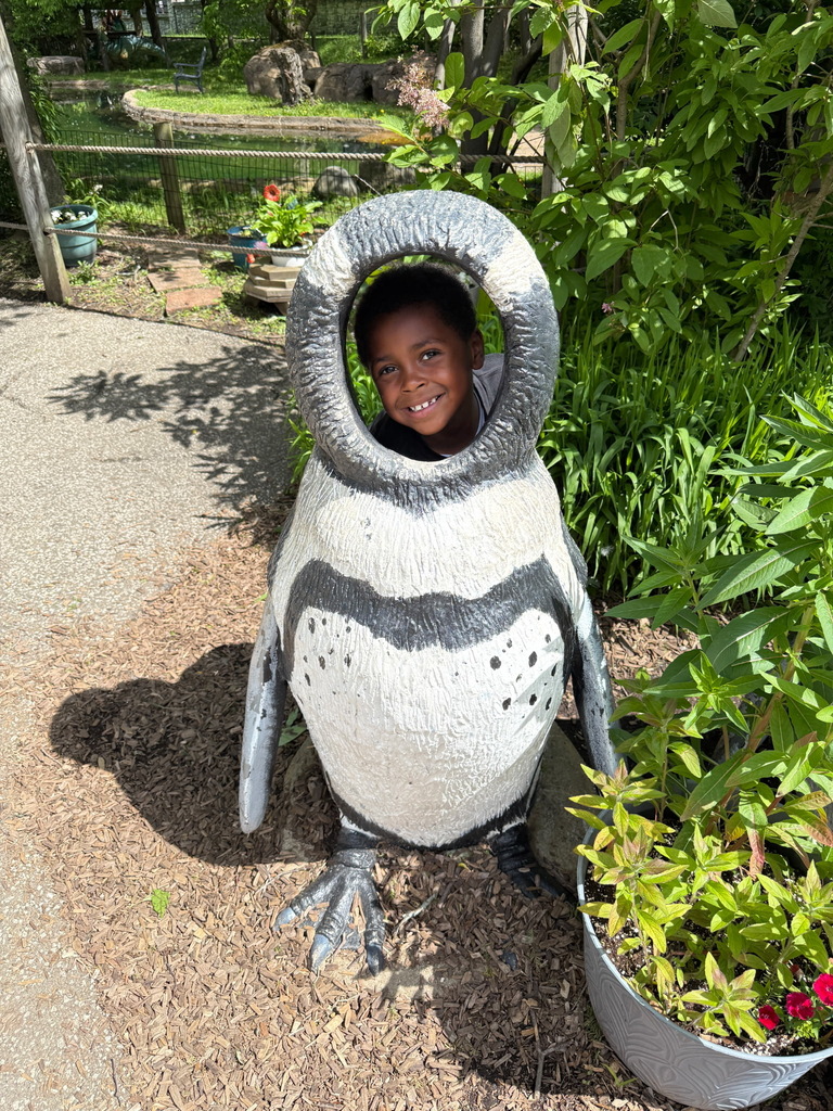 Student inside a large penguin photo prop.