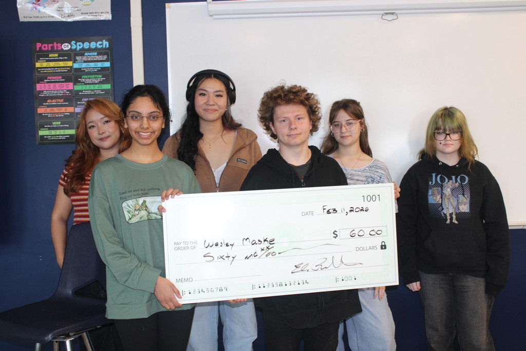 Freshman Wesley Maske accepts a prize check for his winning poem in The Pride's poetry contest