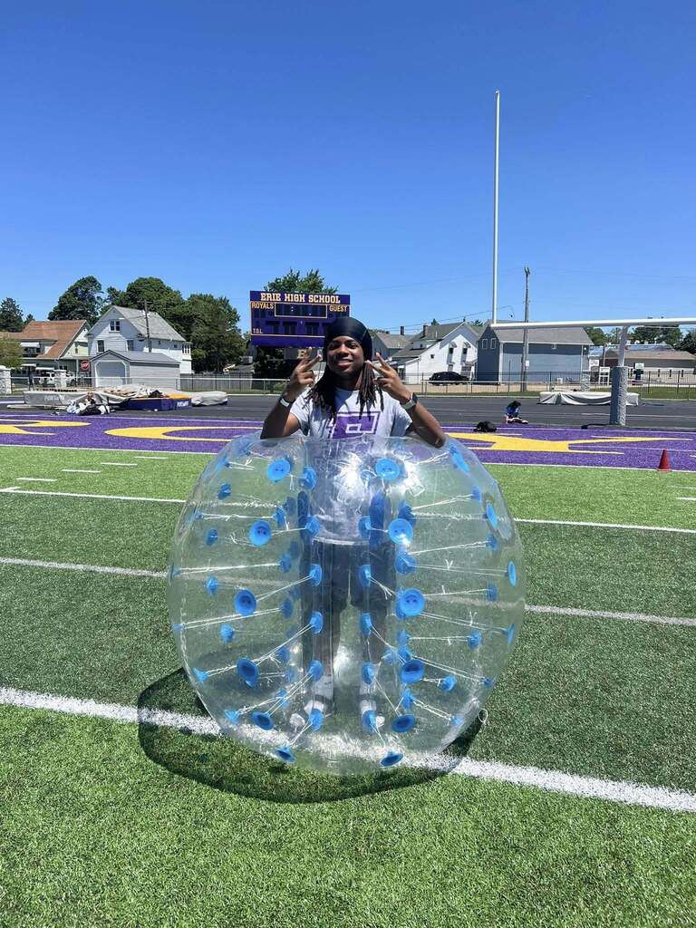 Student posing in an inflatable bumper ball.