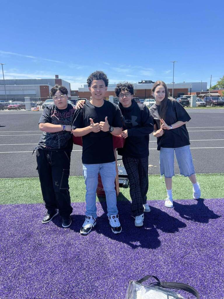 Four Erie High students posing on Erie High field during field day.