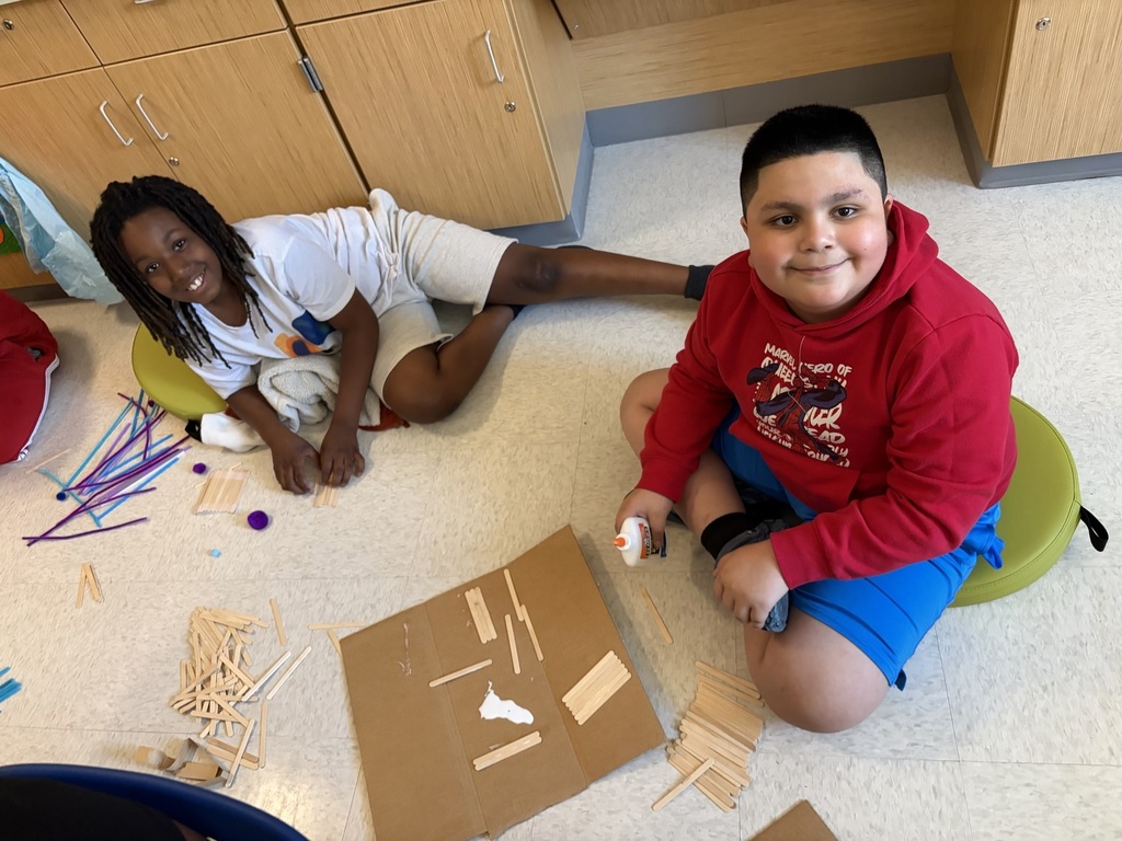Students using materials to construct their own boats.