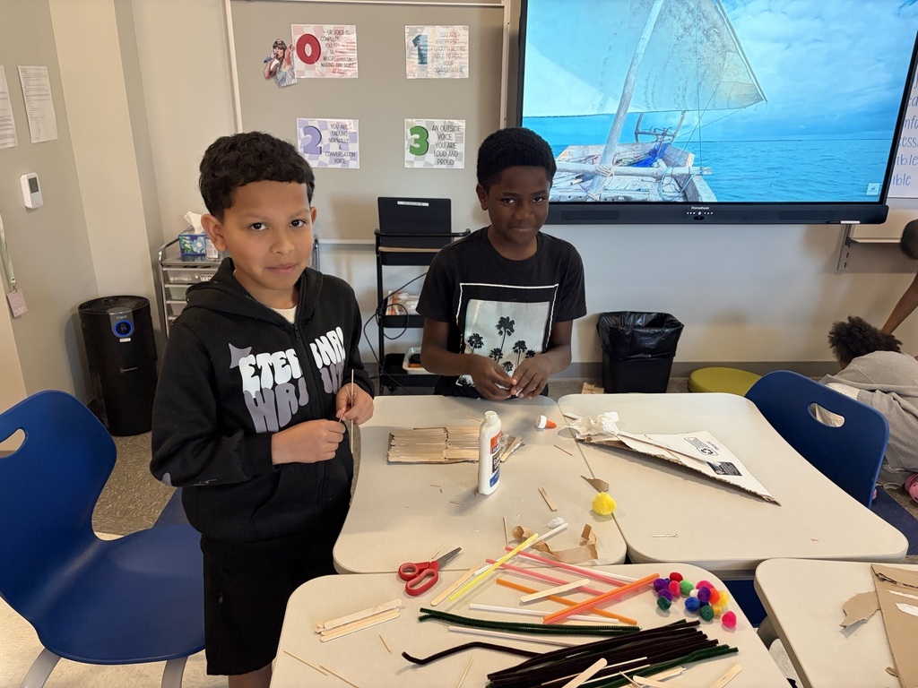 Students using materials to construct their own boats.