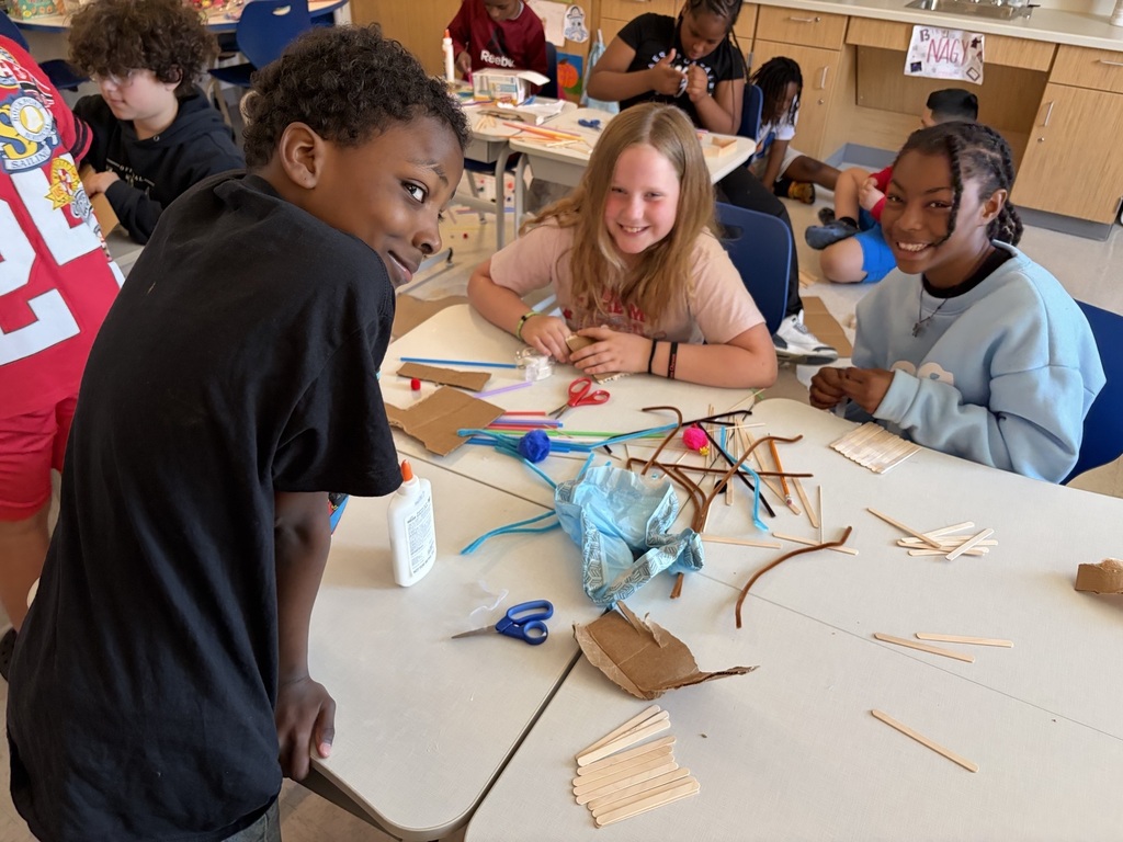 Students using materials to construct their own boats.
