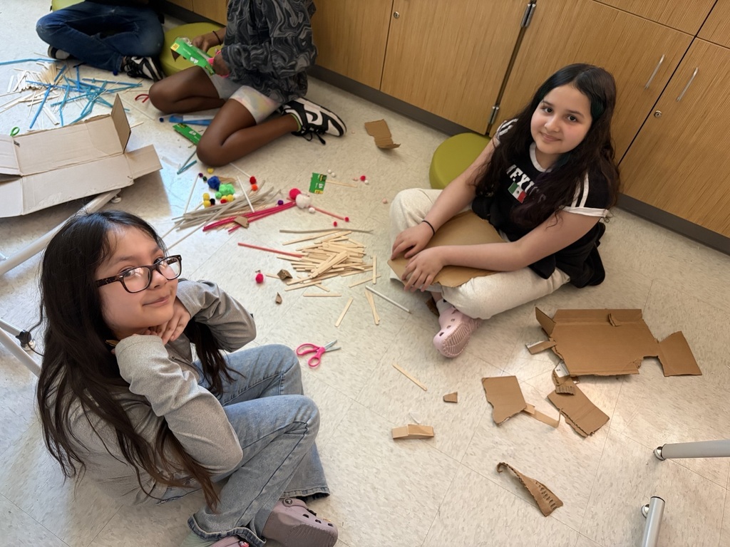 Students using materials to construct their own boats.