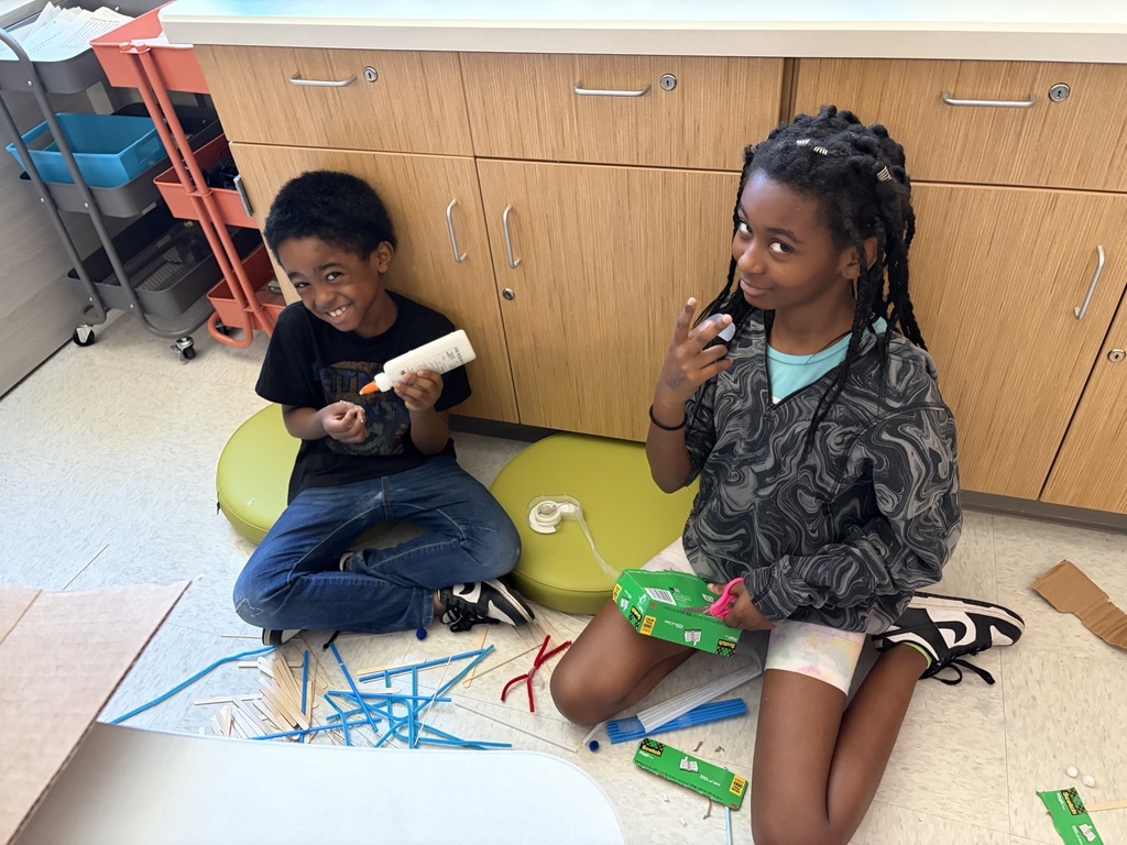 Students using materials to construct their own boats.