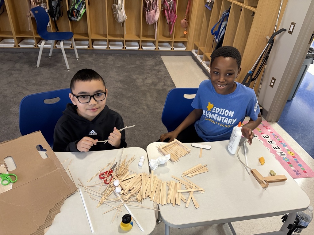 Students using materials to construct their own boats.