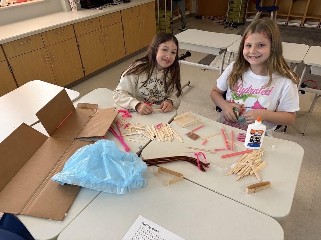 Students using materials to construct their own boats.