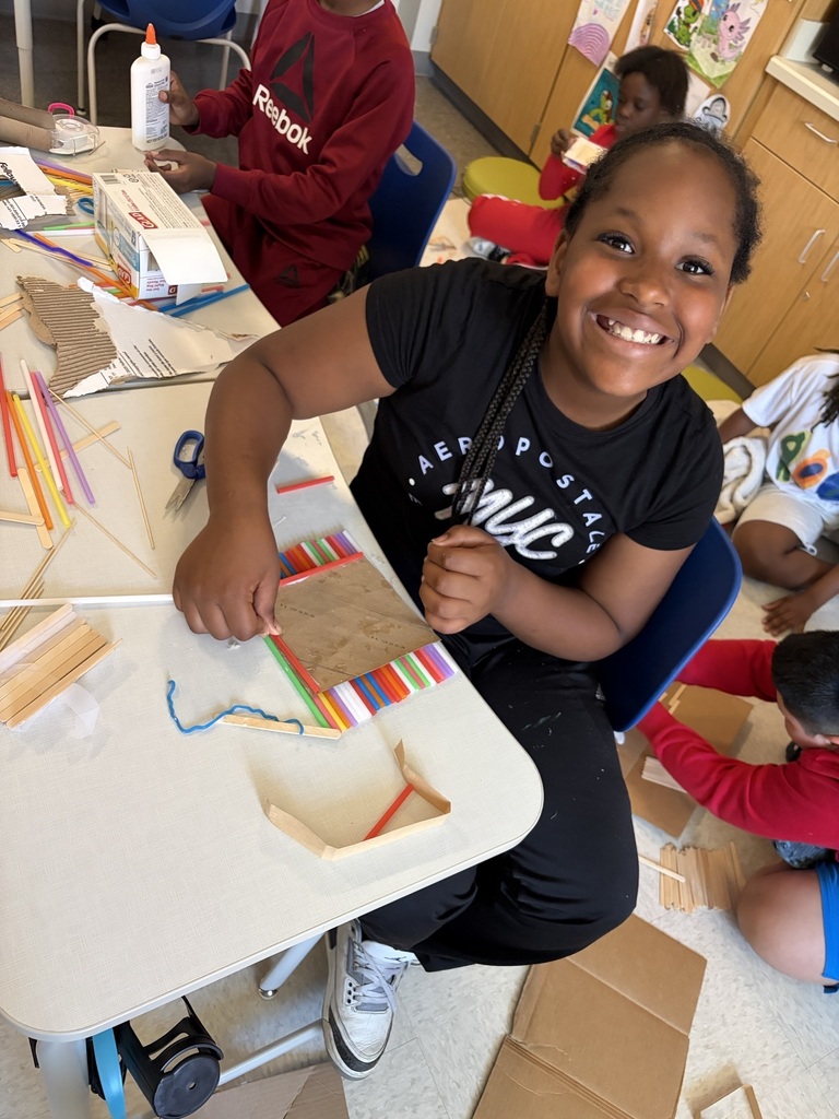 Students using materials to construct their own boats.