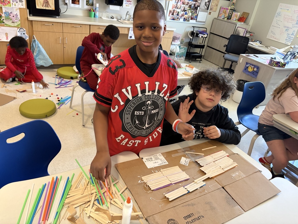 Students using materials to construct their own boats.