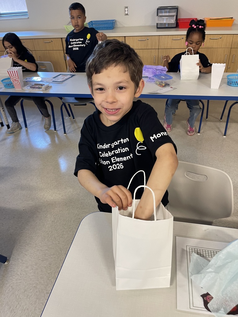 Student smiling with their end of the year gift.