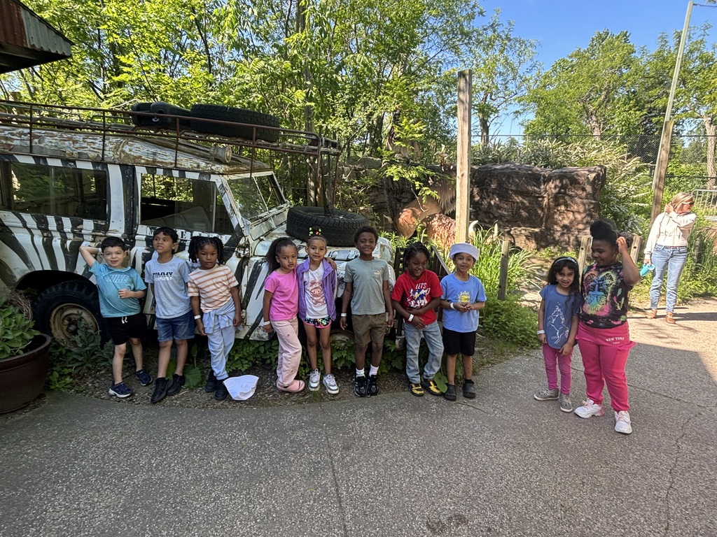 Students posing in front of the jeep at the zoo.
