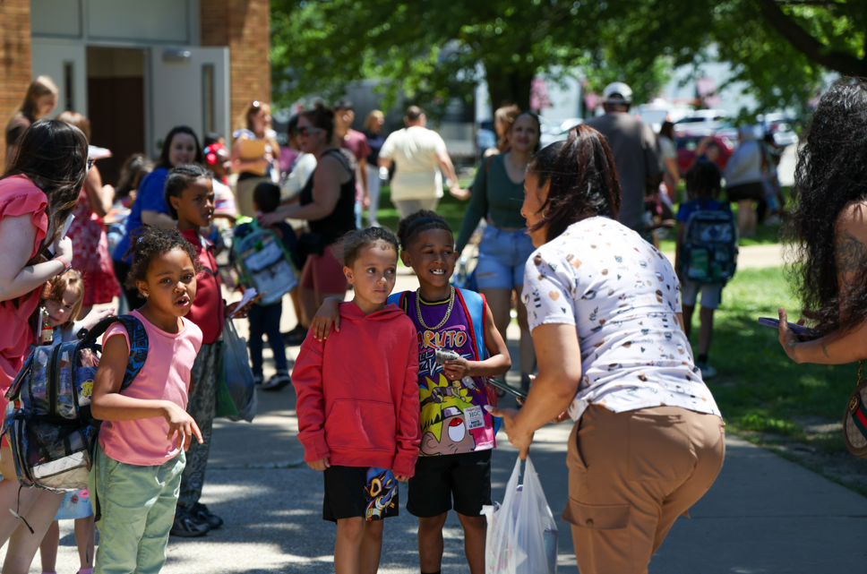 Students smiling as they leave on the last day of school. 