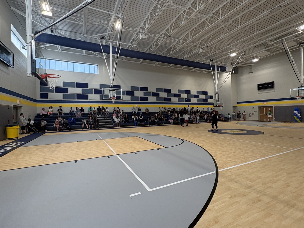 Families in the gym sitting on bleachers.