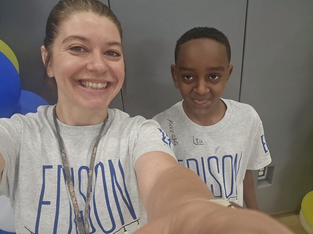 Student smiling for a picture with his teacher. 