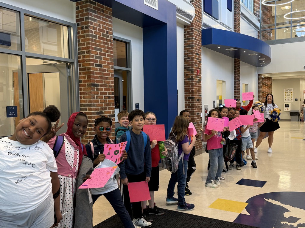 Students in the hallway holding handmade signs.