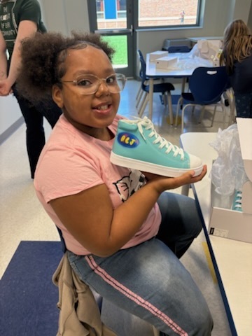 Student with their finished sneakers.