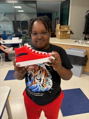 Student with their finished sneakers.