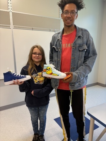Student with their finished sneakers.