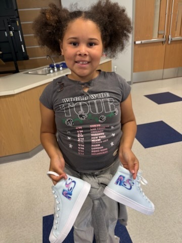 Student with their finished sneakers.