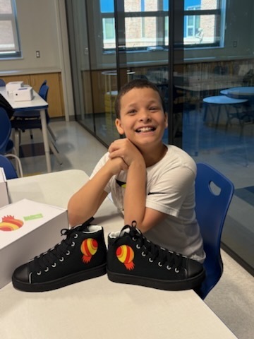 Student with their finished sneakers.