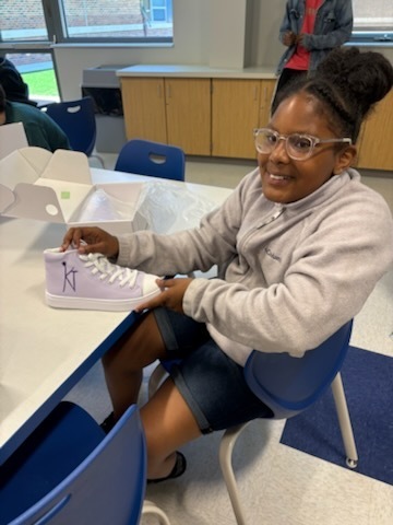 Student with their finished sneakers.