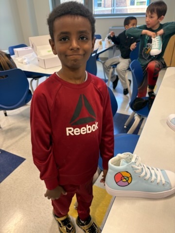 Student with their finished sneakers.