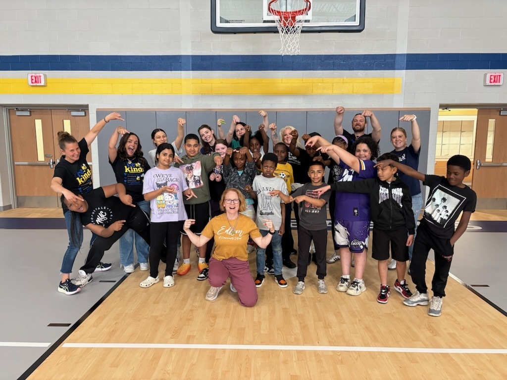 Students and staff posing for a photo in the gym.