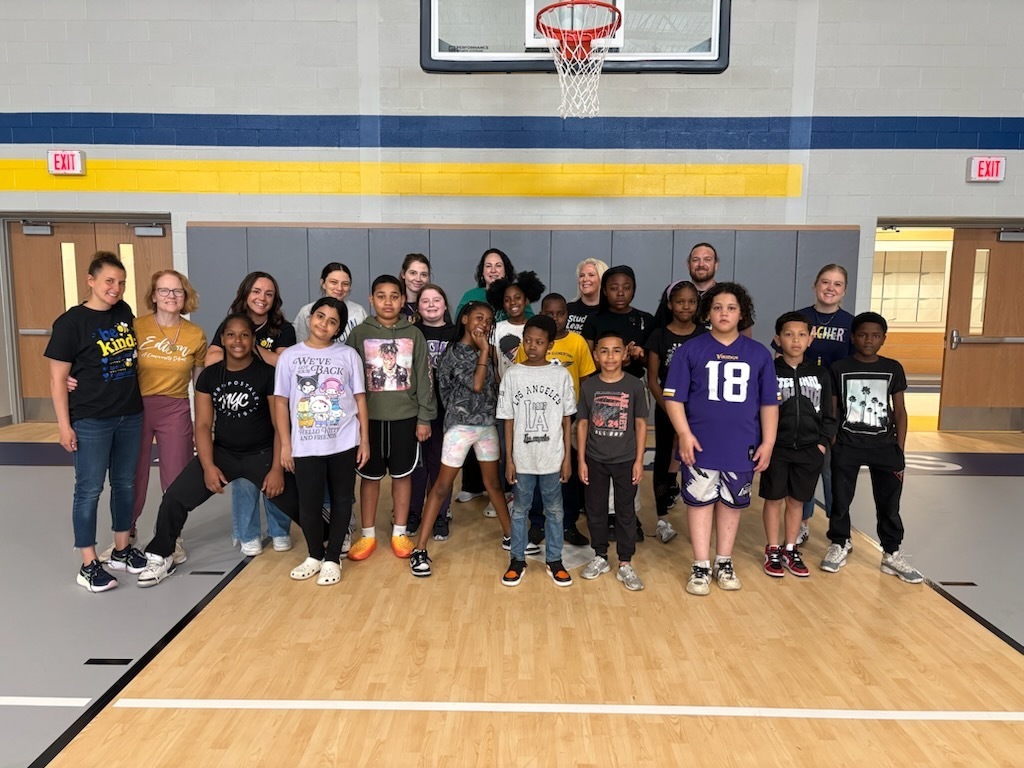 Students and staff posing for a photo in the gym.