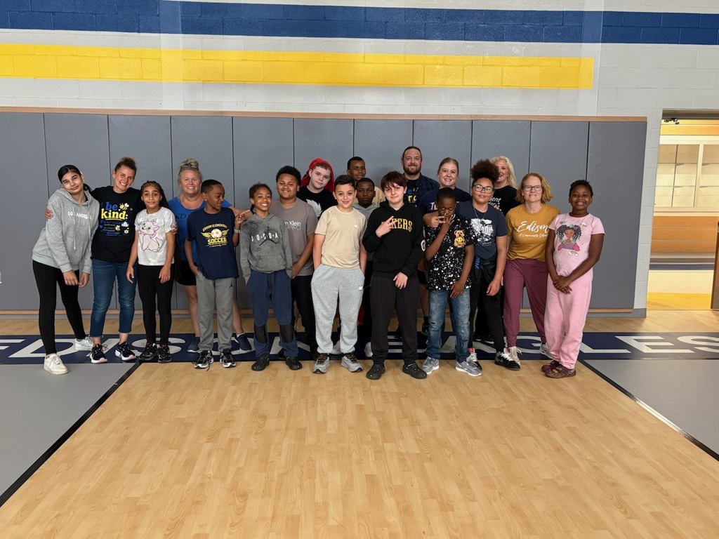 Students and staff posing for a photo in the gym.