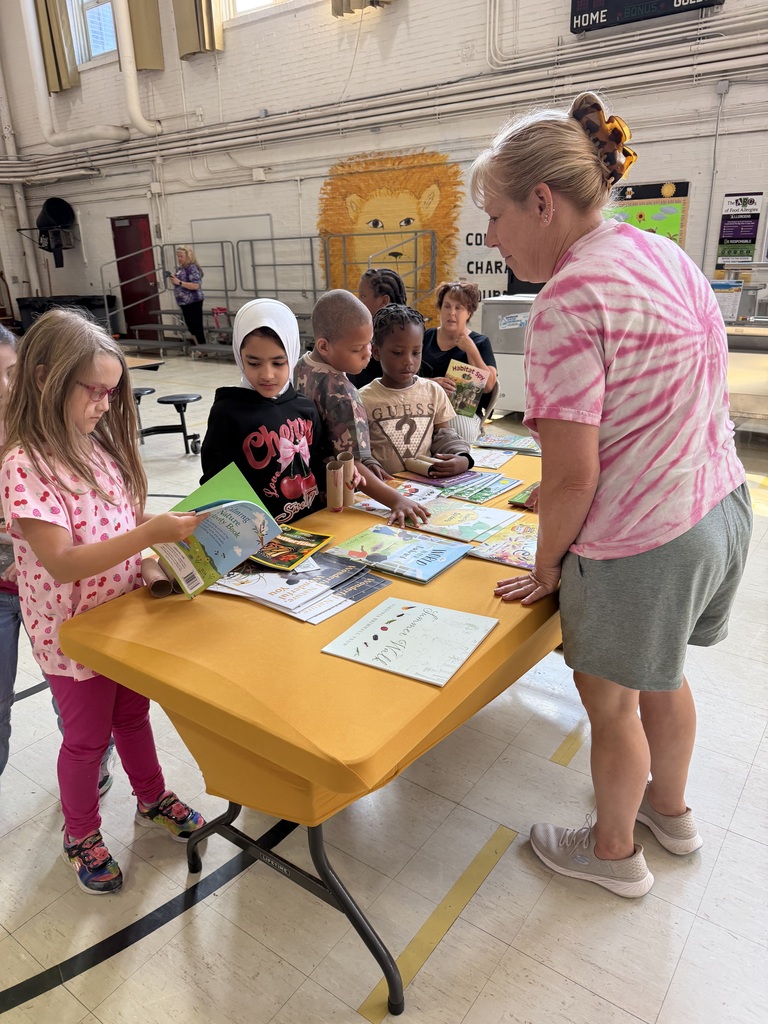Students choosing books from a table