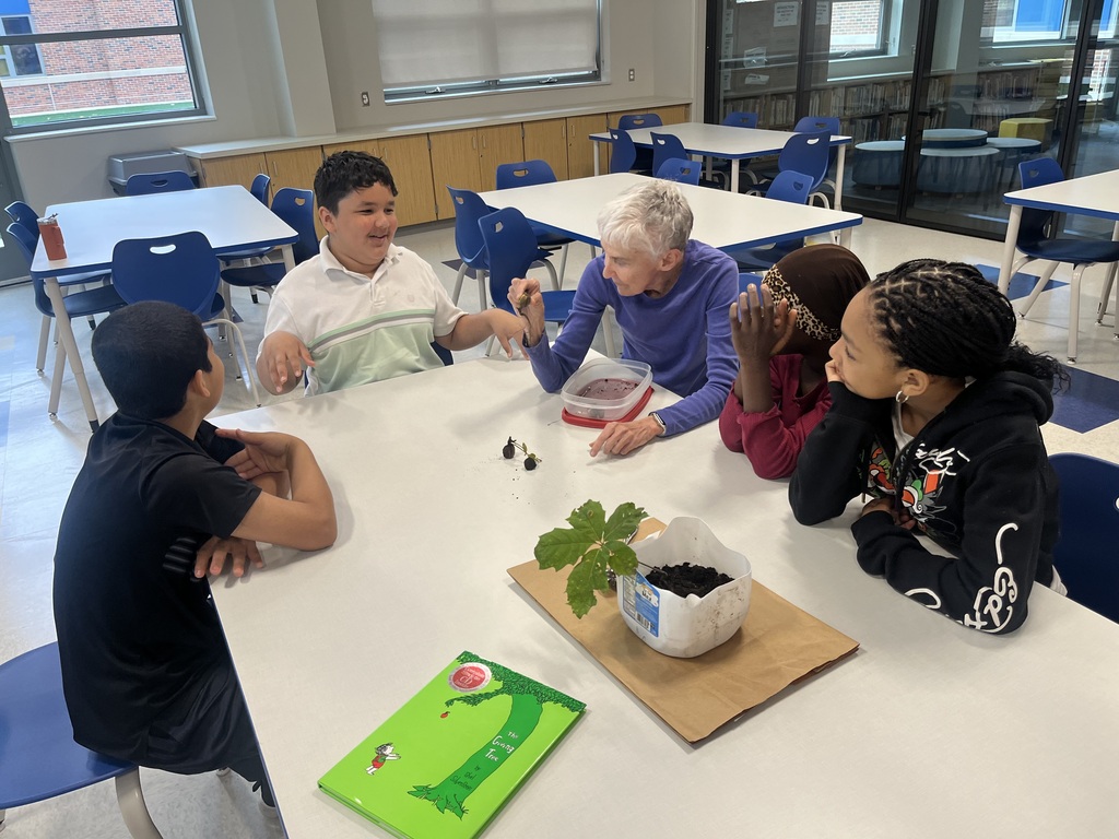Students and volunteer looking at a plant.