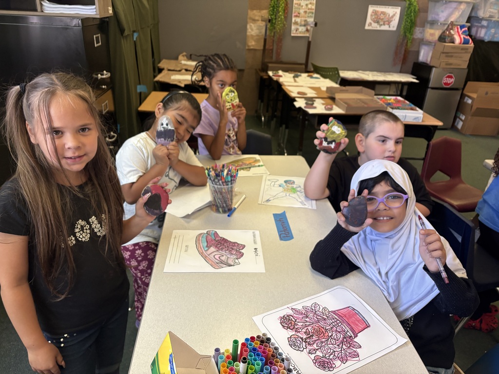 Students holding the rocks they painted.