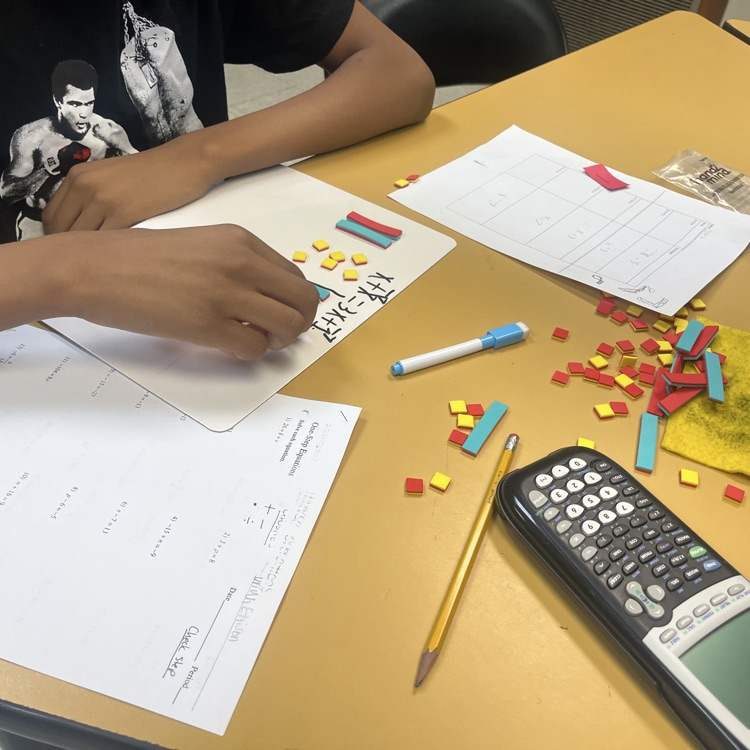 Student doing math with tiles.