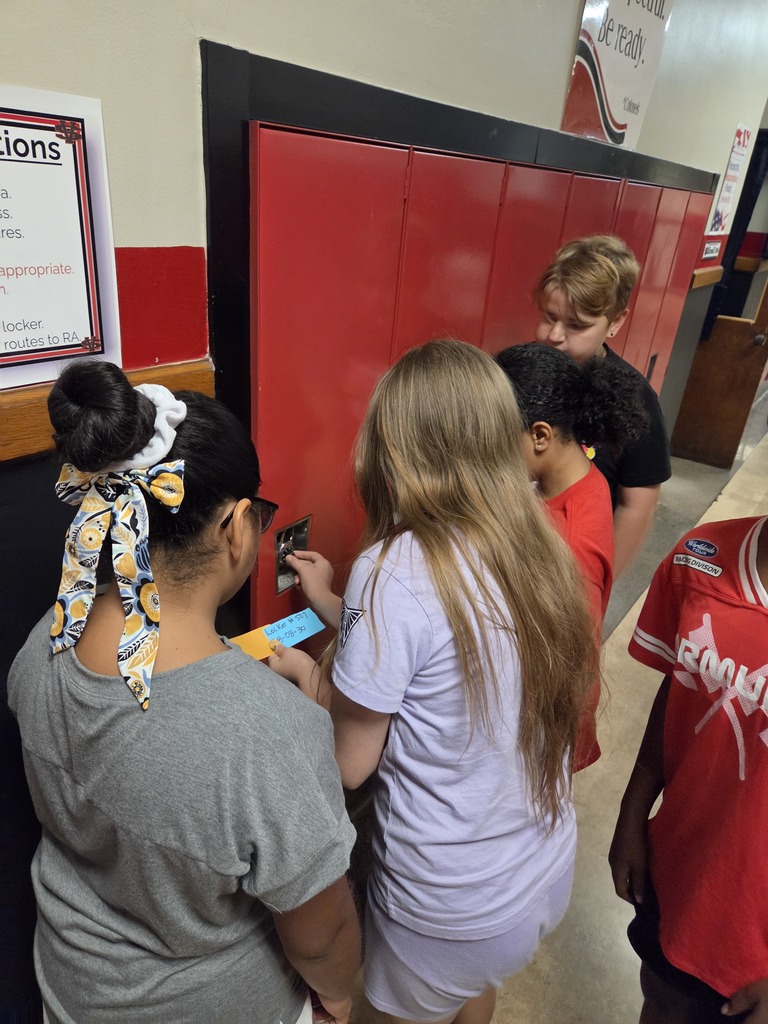 Students figuring out how to open a combination lock on a locker