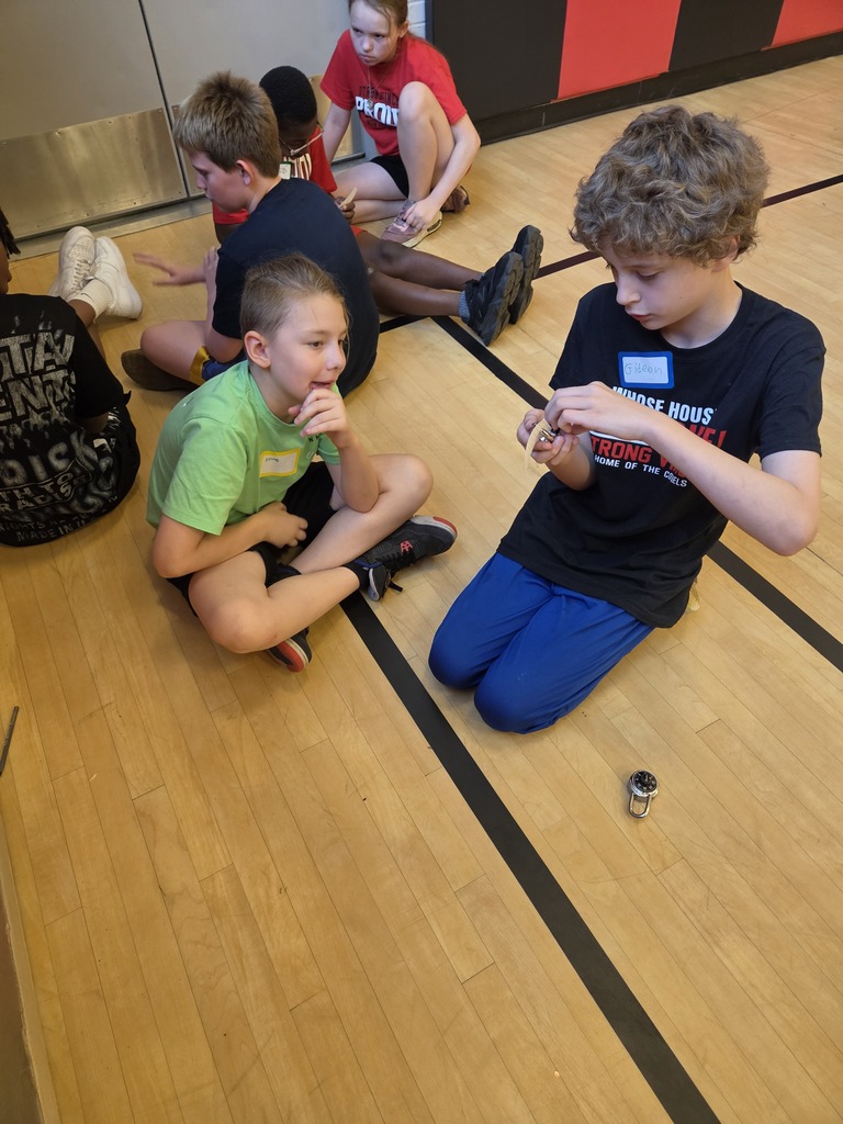 Students helping each other learn how to open a combination lock