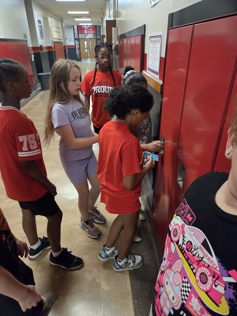 Students figuring out how to open a combination lock on a locker