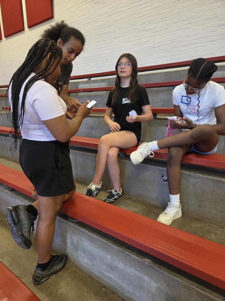 Students helping each other learn how to open a combination lock