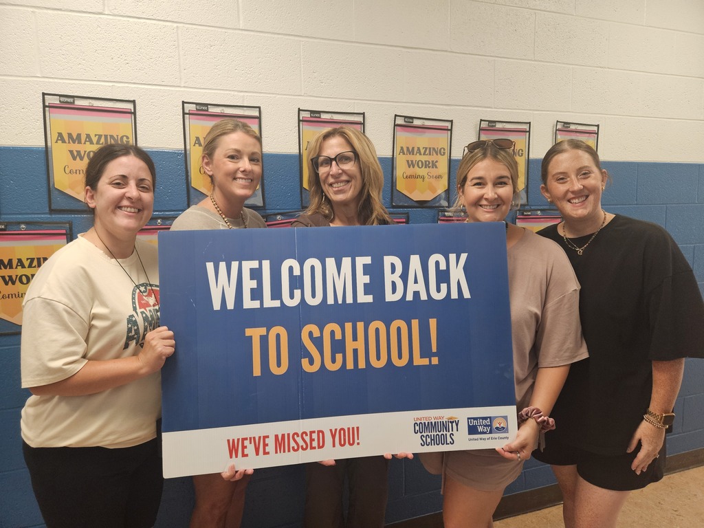 Teachers holding a welcome back sign