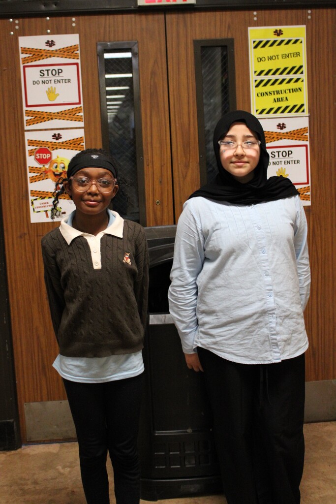 Two female students standing by the doors