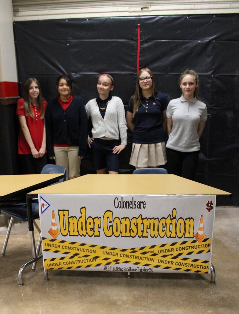 Students standing by an Under Construction sign