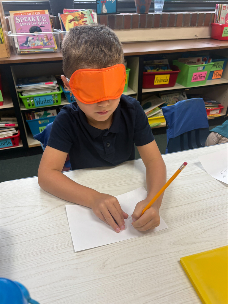 Student writing with an eye mask on