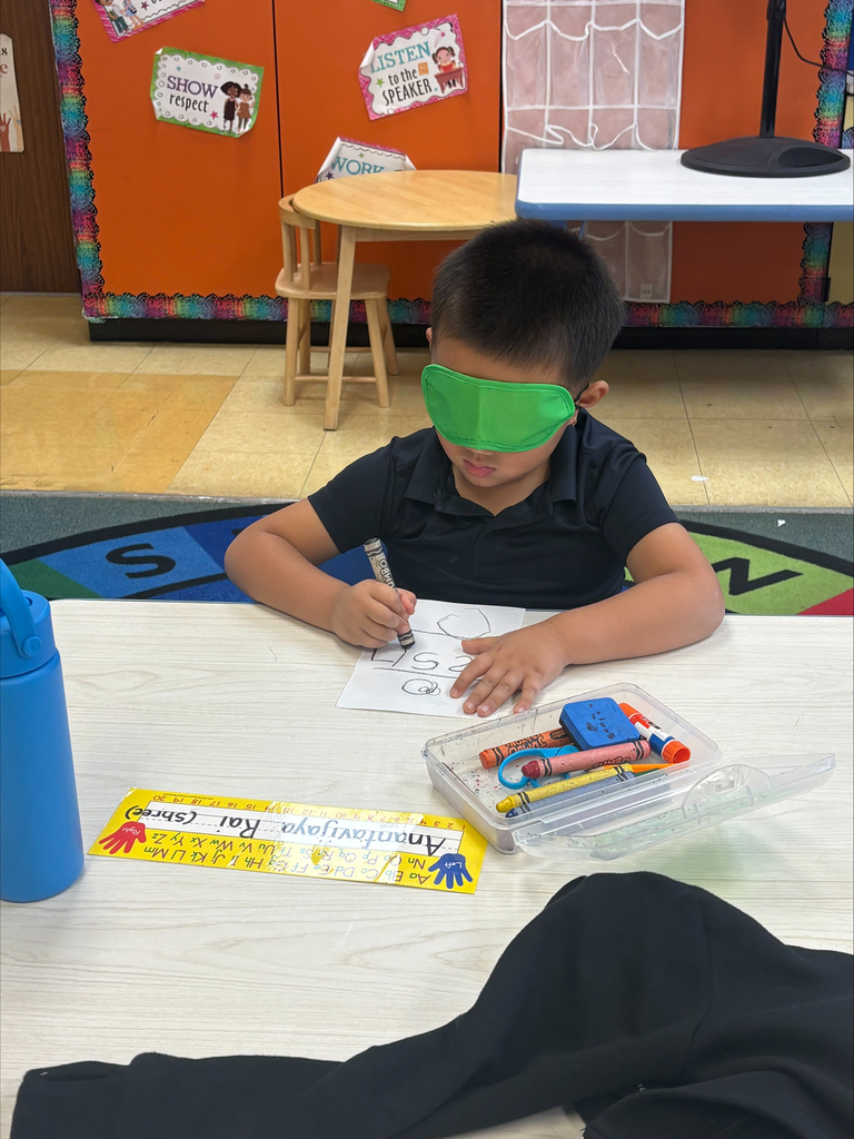Student coloring with an eye mask on