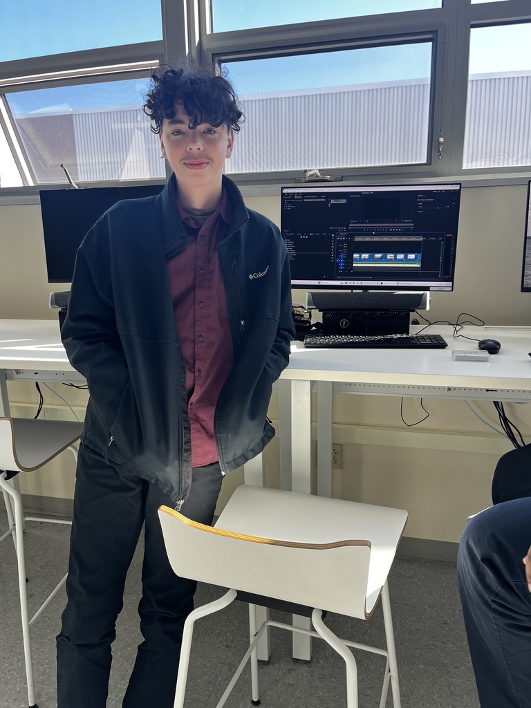 student standing next to a computer