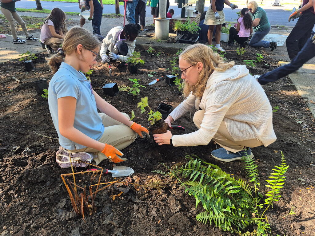 Ms Liz planting with a student