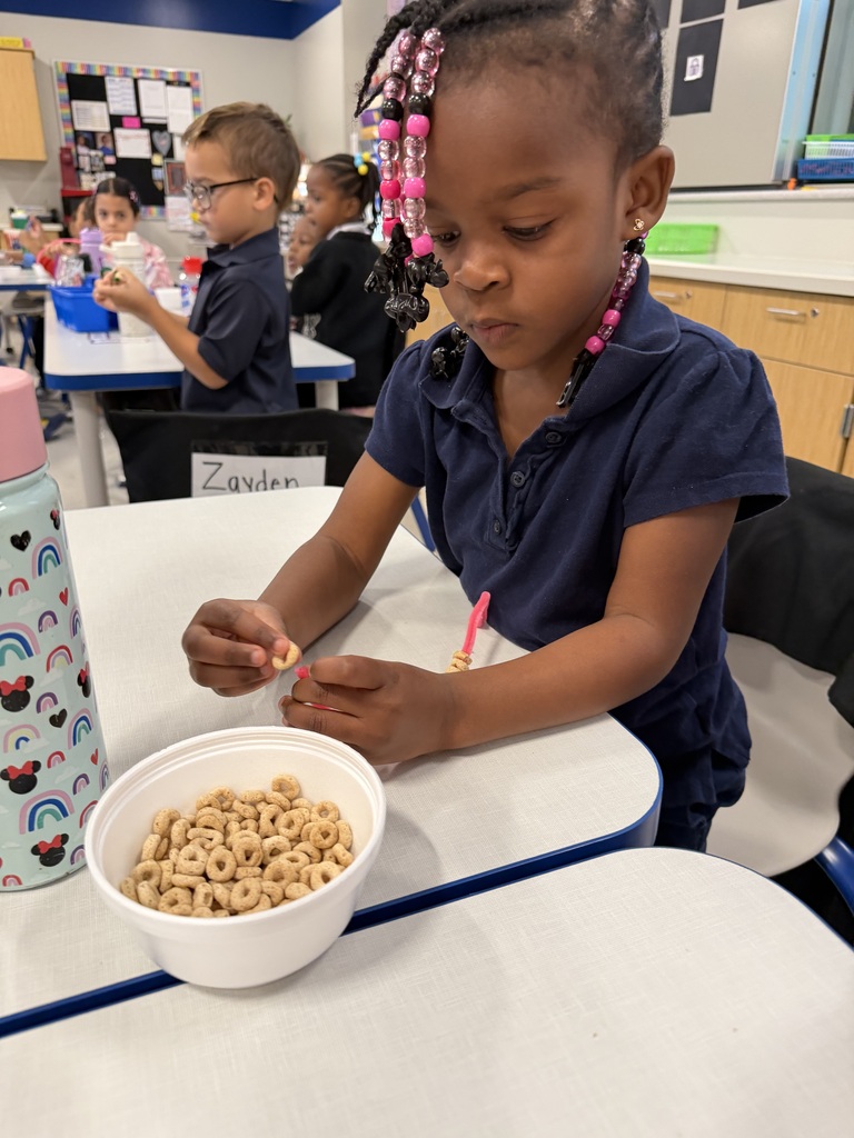 Student stringing Cheerios on a pipe cleaner