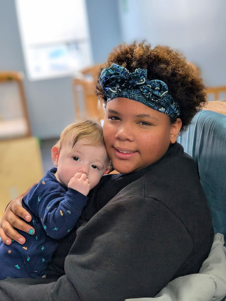 Erie High Deliliah student holding a child from the daycare.