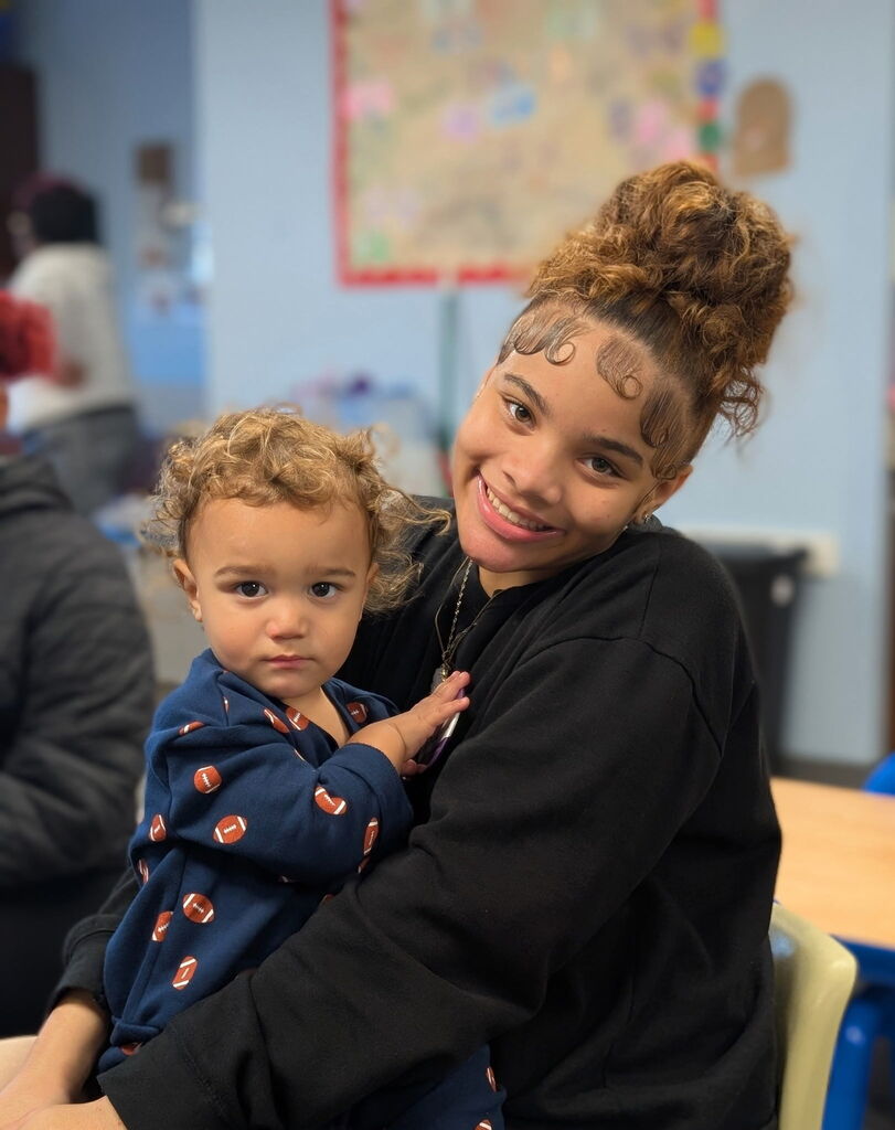 Erie High student Johaunna holding one a child in the infant room.