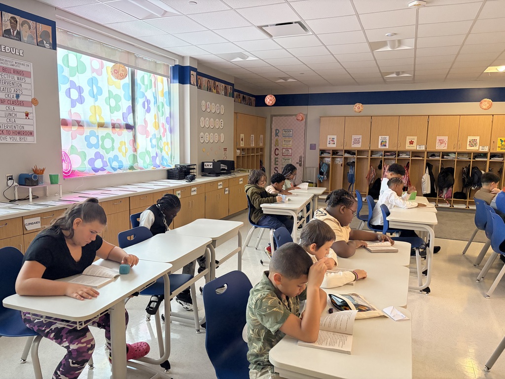 Students sitting at their desks looking through books.